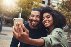 Χαμογελώντας νέο ζεύγος που παίρνει selfie στο πάρκο πόλεων στοκ φωτογραφίες με δικαίωμα ελεύθερης χρήσης Χαμογελώντας νέο ζεύγος που παίρνει selfie στο πάρκο πόλεων στοκ φωτογραφίες με δικαίωμα ελεύθερης χρήσης