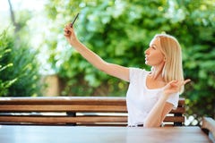 Χαμογελώντας νέο κορίτσι που κάνει selfie τη φωτογραφία στο smartphone στοκ φωτογραφίες Χαμογελώντας νέο κορίτσι που κάνει selfie τη φωτογραφία στο smartphone στοκ φωτογραφίες