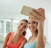 Χαριτωμένα κορίτσια που παίρνουν selfies στο σπίτι στοκ εικόνες Χαριτωμένα κορίτσια που παίρνουν selfies στο σπίτι στοκ εικόνες
