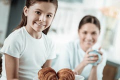 Χαριτωμένη μαθήτρια που τρώει τα νόστιμα croissants στην κουζίνα στοκ εικόνες Χαριτωμένη μαθήτρια που τρώει τα νόστιμα croissants στην κουζίνα στοκ εικόνες