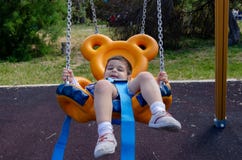 Χαριτωμένο χρονών αγόρι δύο playig στην παιδική χαρά παιδιών υπαίθρια στη teddy ταλάντευση αρκούδων στοκ φωτογραφία Χαριτωμένο χρονών αγόρι δύο playig στην παιδική χαρά παιδιών υπαίθρια στη teddy ταλάντευση αρκούδων στοκ φωτογραφία