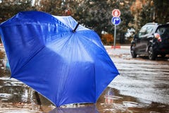 Χειμερινός καιρός στο Ισραήλ Βροχή, ομπρέλα στη διαμορφωμένη λακκούβα, κύκλοι στο νερό και σταγόνες βροχής στοκ εικόνα Χειμερινός καιρός στο Ισραήλ Βροχή, ομπρέλα στη διαμορφωμένη λακκούβα, κύκλοι στο νερό και σταγόνες βροχής στοκ εικόνα