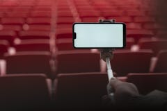 Χλεύη επάνω σε Smartphone με ένα ραβδί selfie στα χέρια ενός ατόμου στο υπόβαθρο των στάσεων Ο τύπος παίρνει ένα selfie στοκ εικόνες Χλεύη επάνω σε Smartphone με ένα ραβδί selfie στα χέρια ενός ατόμου στο υπόβαθρο των στάσεων Ο τύπος παίρνει ένα selfie στοκ εικόνες