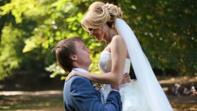 Χορός newlyweds στο ηλιόλουστο πάρκο Ο όμορφος νεόνυμφος περιστρέφει στον αέρα τις νεολαίες του που χαμογελούν την ξανθή νύφη φιλμ μικρού μήκους Χορός newlyweds στο ηλιόλουστο πάρκο Ο όμορφος νεόνυμφος περιστρέφει στον αέρα τις νεολαίες του που χαμογελούν την ξανθή νύφη φιλμ μικρού μήκους