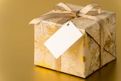 Χριστουγεννιάτικο δώρο με τη χρυσή κορδέλλα και την κενή ετικέττα στοκ φωτογραφίες με δικαίωμα ελεύθερης χρήσης Χριστουγεννιάτικο δώρο με τη χρυσή κορδέλλα και την κενή ετικέττα στοκ φωτογραφίες με δικαίωμα ελεύθερης χρήσης