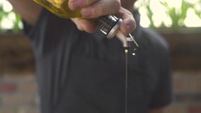 Χύνοντας ελαιόλαδο μαγείρων αρχιμαγείρων από το μπουκάλι μαγειρεύοντας τα υγιή τρόφιμα στην κουζίνα Αρσενικό μπουκάλι και έκχυση απόθεμα βίντεο Χύνοντας ελαιόλαδο μαγείρων αρχιμαγείρων από το μπουκάλι μαγειρεύοντας τα υγιή τρόφιμα στην κουζίνα Αρσενικό μπουκάλι και έκχυση απόθεμα βίντεο