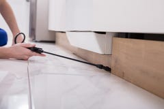 Ψεκάζοντας φυτοφάρμακο εργαζομένων ελέγχου παρασίτων στο ξύλινο γραφείο στοκ εικόνες Ψεκάζοντας φυτοφάρμακο εργαζομένων ελέγχου παρασίτων στο ξύλινο γραφείο στοκ εικόνες