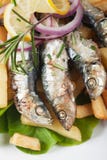 Ψημένα στη σχάρα ψάρια σαρδελλών με τις τηγανιτές πατάτες Στοκ φωτογραφίες με δικαίωμα ελεύθερης χρήσης Ψημένα στη σχάρα ψάρια σαρδελλών με τις τηγανιτές πατάτες Στοκ φωτογραφίες με δικαίωμα ελεύθερης χρήσης