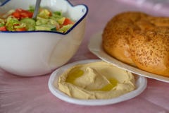 Ψωμί Challah σε έναν πίνακα για το γεύμα Shabbat και παραδοσιακό σπιτικό hummus, σαλάτα στο ρόδινο πίνακα Εβραϊκή κουζίνα στοκ εικόνες Ψωμί Challah σε έναν πίνακα για το γεύμα Shabbat και παραδοσιακό σπιτικό hummus, σαλάτα στο ρόδινο πίνακα Εβραϊκή κουζίνα στοκ εικόνες