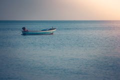 Όμορφη seascape άποψη του αλιευτικού σκάφους που επιπλέει στη θάλασσα με το φως ηλιοβασιλέματος στο υπόβαθρο Στοκ Εικόνα Όμορφη seascape άποψη του αλιευτικού σκάφους που επιπλέει στη θάλασσα με το φως ηλιοβασιλέματος στο υπόβαθρο Στοκ Εικόνα