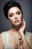 Όμορφη γυναίκα brunette με το τέλειο δέρμα, το χρυσό makeup και το χειροποίητο κόσμημα Πρόσωπο ομορφιάς στοκ εικόνες με δικαίωμα ελεύθερης χρήσης Όμορφη γυναίκα brunette με το τέλειο δέρμα, το χρυσό makeup και το χειροποίητο κόσμημα Πρόσωπο ομορφιάς στοκ εικόνες με δικαίωμα ελεύθερης χρήσης