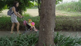 Όμορφη γυναίκα με τις αφρικανικές πλεξούδες που φέρνουν το μικρό κορίτσι στο καροτσάκι απόθεμα βίντεο Όμορφη γυναίκα με τις αφρικανικές πλεξούδες που φέρνουν το μικρό κορίτσι στο καροτσάκι απόθεμα βίντεο