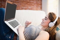Όμορφη γυναίκα που βρίσκεται στον καναπέ που χρησιμοποιεί τη μουσική της lap-top και ακούσματος στοκ φωτογραφία με δικαίωμα ελεύθερης χρήσης Όμορφη γυναίκα που βρίσκεται στον καναπέ που χρησιμοποιεί τη μουσική της lap-top και ακούσματος στοκ φωτογραφία με δικαίωμα ελεύθερης χρήσης
