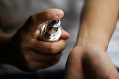 Όμορφη γυναίκα που επιλέγει τα αρώματα με το μπουκάλι του αρώματος στο σκοτάδι Στοκ Φωτογραφία Όμορφη γυναίκα που επιλέγει τα αρώματα με το μπουκάλι του αρώματος στο σκοτάδι Στοκ Φωτογραφία