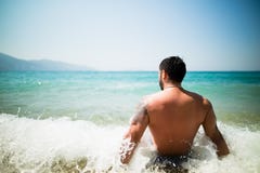 Όμορφη ελκυστική μυϊκή συνεδρίαση ατόμων στην ακροθαλασσιά στην άμμο και τη χαλάρωση παραλιών Όμορφο άτομο με τη δερματοστιξία πο Στοκ φωτογραφίες με δικαίωμα ελεύθερης χρήσης Όμορφη ελκυστική μυϊκή συνεδρίαση ατόμων στην ακροθαλασσιά στην άμμο και τη χαλάρωση παραλιών Όμορφο άτομο με τη δερματοστιξία πο Στοκ φωτογραφίες με δικαίωμα ελεύθερης χρήσης