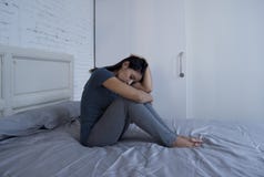 Όμορφη λυπημένη και καταθλιπτική λατινική συνεδρίαση γυναικών στο κρεβάτι στο σπίτι φ στοκ φωτογραφία Όμορφη λυπημένη και καταθλιπτική λατινική συνεδρίαση γυναικών στο κρεβάτι στο σπίτι φ στοκ φωτογραφία