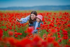 Όμορφη νέα γυναίκα με το κορίτσι παιδιών στον τομέα παπαρουνών ευτυχής οικογένεια που έχει τη διασκέδαση στη φύση υπαίθριο πορτρέ στοκ εικόνες Όμορφη νέα γυναίκα με το κορίτσι παιδιών στον τομέα παπαρουνών ευτυχής οικογένεια που έχει τη διασκέδαση στη φύση υπαίθριο πορτρέ στοκ εικόνες