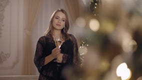 Όμορφη νέα γυναίκα που στέκεται και που θέτει στο υπόβαθρο Χριστουγέννων απόθεμα βίντεο Όμορφη νέα γυναίκα που στέκεται και που θέτει στο υπόβαθρο Χριστουγέννων απόθεμα βίντεο