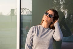 Όμορφη νέα εφηβική τοποθέτηση κοριτσιών χαμόγελου μπροστά από το παράθυρο γυαλιού Στοκ φωτογραφία με δικαίωμα ελεύθερης χρήσης Όμορφη νέα εφηβική τοποθέτηση κοριτσιών χαμόγελου μπροστά από το παράθυρο γυαλιού Στοκ φωτογραφία με δικαίωμα ελεύθερης χρήσης