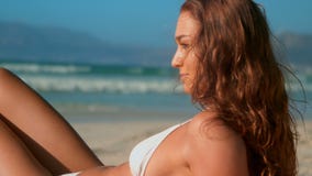 Όμορφη νέα καυκάσια γυναίκα στη χαλάρωση μπικινιών στην παραλία στην ηλιοφάνεια απόθεμα βίντεο Όμορφη νέα καυκάσια γυναίκα στη χαλάρωση μπικινιών στην παραλία στην ηλιοφάνεια απόθεμα βίντεο