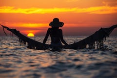 Όμορφη νέα σκιαγραφία γυναικών με την τοποθέτηση ταλάντευσης στη θάλα στοκ εικόνες Όμορφη νέα σκιαγραφία γυναικών με την τοποθέτηση ταλάντευσης στη θάλα στοκ εικόνες