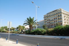 Όμορφη οδός με τους φοίνικες και τα ακριβά ξενοδοχεία στην Κρήτη στοκ εικόνα Όμορφη οδός με τους φοίνικες και τα ακριβά ξενοδοχεία στην Κρήτη στοκ εικόνα