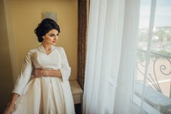 Όμορφη προκλητική νύφη στην άσπρη τοποθέτηση φορεμάτων κάτω από την κουρτίνα στοκ εικόνα με δικαίωμα ελεύθερης χρήσης Όμορφη προκλητική νύφη στην άσπρη τοποθέτηση φορεμάτων κάτω από την κουρτίνα στοκ εικόνα με δικαίωμα ελεύθερης χρήσης