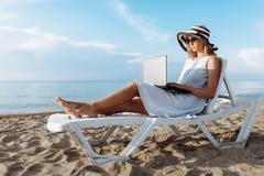 Όμορφη συνεδρίαση κοριτσιών με ένα lap-top σε ένα μόνιππο longue, μια γυναίκα που εργάζεται στις διακοπές, αναζήτηση εργασίας στοκ εικόνα με δικαίωμα ελεύθερης χρήσης Όμορφη συνεδρίαση κοριτσιών με ένα lap-top σε ένα μόνιππο longue, μια γυναίκα που εργάζεται στις διακοπές, αναζήτηση εργασίας στοκ εικόνα με δικαίωμα ελεύθερης χρήσης