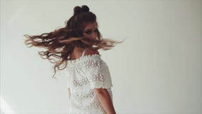 Όμορφη τοποθέτηση brunette γυναικών στο στούντιο στο άσπρο υπόβαθρο και περπάτημα στη κάμερα απόθεμα βίντεο Όμορφη τοποθέτηση brunette γυναικών στο στούντιο στο άσπρο υπόβαθρο και περπάτημα στη κάμερα απόθεμα βίντεο