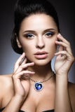 Όμορφο brunette με μια φωτεινή σύνθεση βραδιού με μια καρδιά περιδεραίων του ωκεανού στοκ φωτογραφία με δικαίωμα ελεύθερης χρήσης Όμορφο brunette με μια φωτεινή σύνθεση βραδιού με μια καρδιά περιδεραίων του ωκεανού στοκ φωτογραφία με δικαίωμα ελεύθερης χρήσης