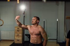 Όμορφο άτομο bodybuilder γυμνοστήθων μυϊκό που παίρνει selfie με το τηλέφωνο κυττάρων στοκ εικόνες Όμορφο άτομο bodybuilder γυμνοστήθων μυϊκό που παίρνει selfie με το τηλέφωνο κυττάρων στοκ εικόνες