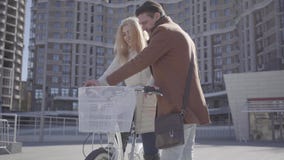 Όμορφο άτομο στο καφετί παλτό που διδάσκει τη φίλη του για να οδηγήσει το ποδήλατο στην πόλη, γέλιο και των δύο ανθρώπων Ελεύθερο απόθεμα βίντεο Όμορφο άτομο στο καφετί παλτό που διδάσκει τη φίλη του για να οδηγήσει το ποδήλατο στην πόλη, γέλιο και των δύο ανθρώπων Ελεύθερο απόθεμα βίντεο