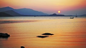 Όμορφο ηλιοβασίλεμα από τη θάλασσα και τα βουνά στο υπόβαθρο Βάρκες που πλέουν εν πλω στο καταπληκτικό ηλιοβασίλεμα κίνηση αργή φιλμ μικρού μήκους Όμορφο ηλιοβασίλεμα από τη θάλασσα και τα βουνά στο υπόβαθρο Βάρκες που πλέουν εν πλω στο καταπληκτικό ηλιοβασίλεμα κίνηση αργή φιλμ μικρού μήκους