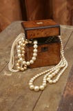 Όμορφο και καλό jewellerybox με τα μαργαριτάρια σε έναν παλαιό πίνακα στοκ εικόνες με δικαίωμα ελεύθερης χρήσης Όμορφο και καλό jewellerybox με τα μαργαριτάρια σε έναν παλαιό πίνακα στοκ εικόνες με δικαίωμα ελεύθερης χρήσης