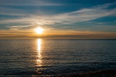 Όμορφο και φωτεινό ηλιοβασίλεμα στην παραλία στους μπλε και κίτρινους τόνους στοκ φωτογραφίες Όμορφο και φωτεινό ηλιοβασίλεμα στην παραλία στους μπλε και κίτρινους τόνους στοκ φωτογραφίες