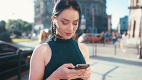 Όμορφο κορίτσι brunette που κοιτάζει ονειρεμένα στην οθόνη κινητών τηλεφώνων της, χαμογελώντας γοητευτικά και texting μήνυμα στεμ φιλμ μικρού μήκους Όμορφο κορίτσι brunette που κοιτάζει ονειρεμένα στην οθόνη κινητών τηλεφώνων της, χαμογελώντας γοητευτικά και texting μήνυμα στεμ φιλμ μικρού μήκους