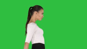 Όμορφο κορίτσι brunette που περπατά με τα χέρια στα ισχία σε μια πράσινη οθόνη, κλειδί χρώματος Όμορφο κορίτσι brunette που περπατά με τα χέρια στα ισχία σε μια πράσινη οθόνη, κλειδί χρώματος