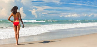 Όμορφο κορίτσι Surfer γυναικών μπικινιών & πανόραμα παραλιών ιστιοσανίδων στοκ εικόνες Όμορφο κορίτσι Surfer γυναικών μπικινιών & πανόραμα παραλιών ιστιοσανίδων στοκ εικόνες