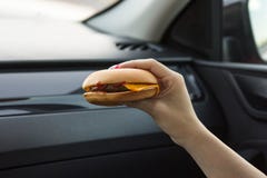 Όμορφο κορίτσι που κρατά cheeseburger με τα χέρια της, κινηματογράφηση σε πρώτο πλάνο σε ένα θολωμένο υπόβαθρο στοκ φωτογραφία με δικαίωμα ελεύθερης χρήσης Όμορφο κορίτσι που κρατά cheeseburger με τα χέρια της, κινηματογράφηση σε πρώτο πλάνο σε ένα θολωμένο υπόβαθρο στοκ φωτογραφία με δικαίωμα ελεύθερης χρήσης