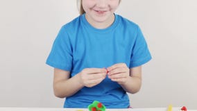 Όμορφο κορίτσι στο σπίτι μπλε φορμών από το plasticine στον άσπρο πίνακα απόθεμα βίντεο Όμορφο κορίτσι στο σπίτι μπλε φορμών από το plasticine στον άσπρο πίνακα απόθεμα βίντεο