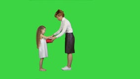 Όμορφο νέο mom που δίνει ένα παρόν στο γοητευτικό μικρό κορίτσι της σε μια πράσινη οθόνη, κλειδί χρώματος απόθεμα βίντεο Όμορφο νέο mom που δίνει ένα παρόν στο γοητευτικό μικρό κορίτσι της σε μια πράσινη οθόνη, κλειδί χρώματος απόθεμα βίντεο