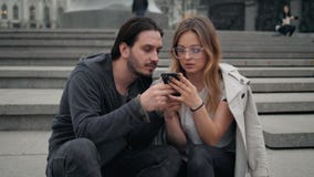 Όμορφοι άνδρας και γυναίκα που περπατούν στην οδό και που κάνουν selfie από τις έξυπνα εφαρμογές και το παιχνίδι τηλεφωνικής χρήσ απόθεμα βίντεο Όμορφοι άνδρας και γυναίκα που περπατούν στην οδό και που κάνουν selfie από τις έξυπνα εφαρμογές και το παιχνίδι τηλεφωνικής χρήσ απόθεμα βίντεο