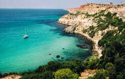 Όμορφος seascape κόλπος με ένα γιοτ, τους βράχους και την πρασινάδα στοκ φωτογραφία με δικαίωμα ελεύθερης χρήσης Όμορφος seascape κόλπος με ένα γιοτ, τους βράχους και την πρασινάδα στοκ φωτογραφία με δικαίωμα ελεύθερης χρήσης