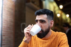 Όμορφος λατινικός καφές κατανάλωσης τύπων σε έναν καφέ πεζουλιών στοκ εικόνα Όμορφος λατινικός καφές κατανάλωσης τύπων σε έναν καφέ πεζουλιών στοκ εικόνα