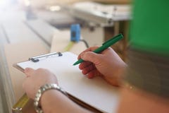 Όπλα του εργαζομένου που κάνει τις σημειώσεις για την περιοχή αποκομμάτων με την πράσινη μάνδρα στοκ φωτογραφία με δικαίωμα ελεύθερης χρήσης Όπλα του εργαζομένου που κάνει τις σημειώσεις για την περιοχή αποκομμάτων με την πράσινη μάνδρα στοκ φωτογραφία με δικαίωμα ελεύθερης χρήσης