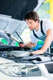 Автоматический механик работая в мастерской обслуживания автомобиля стоковая фотография Автоматический механик работая в мастерской обслуживания автомобиля стоковая фотография