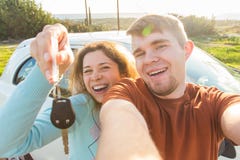 Автоматическое дело, продажа автомобиля, дело и концепция людей - счастливая смешная красивая пара показывает ключ с новым автомо стоковое изображение rf Автоматическое дело, продажа автомобиля, дело и концепция людей - счастливая смешная красивая пара показывает ключ с новым автомо стоковое изображение rf