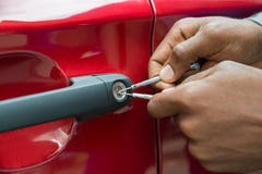 Автомобильная дверь отверстия руки персоны с Lockpicker стоковые изображения rf Автомобильная дверь отверстия руки персоны с Lockpicker стоковые изображения rf