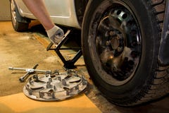 Автомобиль Mechanician изменяя катит внутри гараж Человек обменивая автошину r стоковые изображения Автомобиль Mechanician изменяя катит внутри гараж Человек обменивая автошину r стоковые изображения