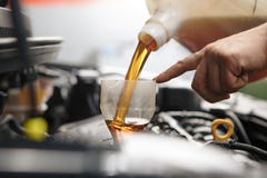 Автотракторное масло механика автомобиля Profecional изменяя в двигателе автомобиля на станции ремонтных услуг обслуживания в мас Стоковое фото RF Автотракторное масло механика автомобиля Profecional изменяя в двигателе автомобиля на станции ремонтных услуг обслуживания в мас Стоковое фото RF